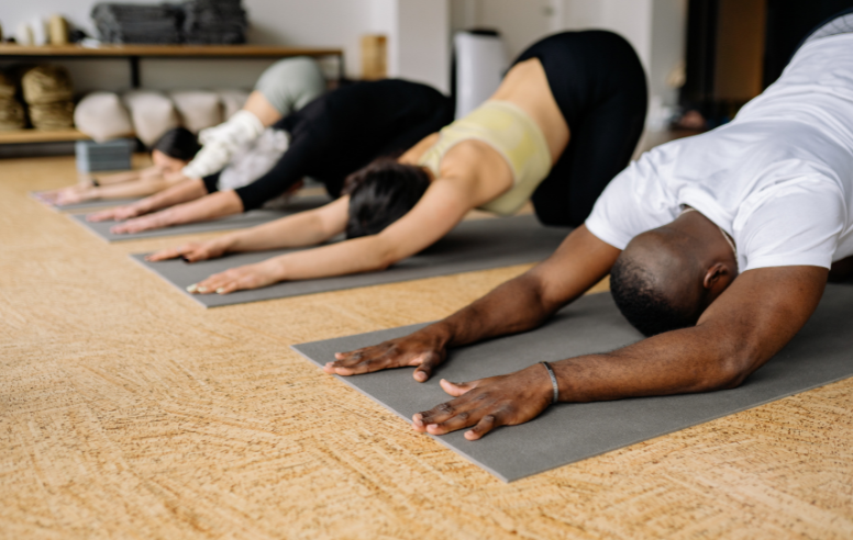 Group of people in the child's pose during yoga.