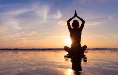 Person practicing yoga during the sunset.